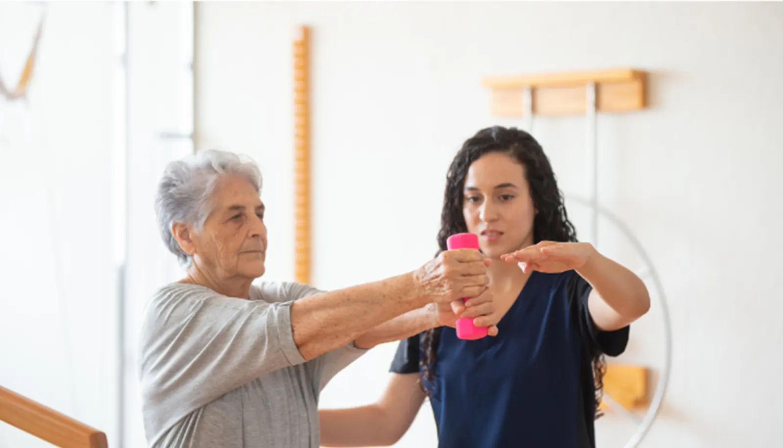 Physical therapist guiding a patient through an upper-body exercise