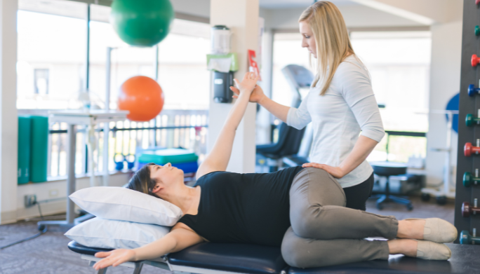 Physical therapist guiding a patient through a leg stretch