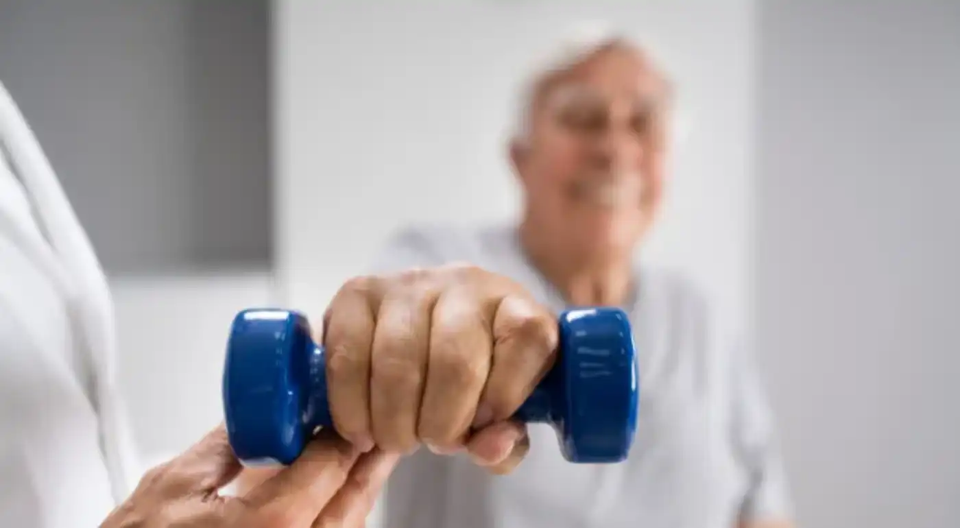Patient strengthening with a dumbbell, guided by a physical therapist
